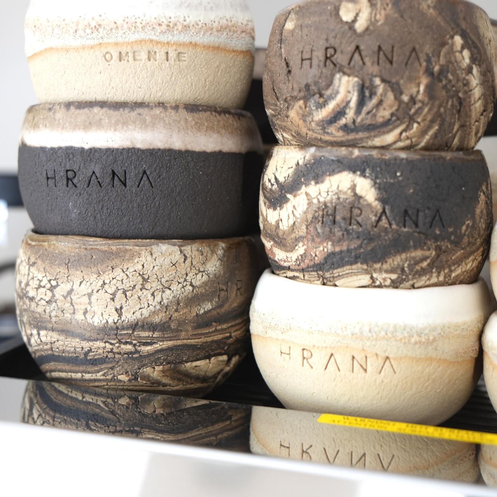 Ciotole di ceramica fatte a mano con il logo HRANA, impilate